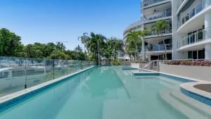 a swimming pool in front of a building at Ocean View 3-Bedroom Apartment on the Esplanade in Cairns