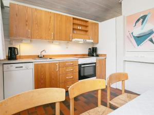 a kitchen with wooden cabinets and a table and chairs at 6 person holiday home in Hanstholm- Type1 in Hanstholm