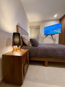 a bedroom with a bed and a table with a lamp at Modern Luxury Residency at Altea-Sunset Pool View in Puerto Vallarta
