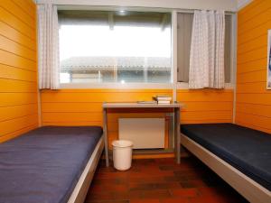 a room with two beds and a table and a window at 6 person holiday home in Hanstholm- Type1 in Hanstholm