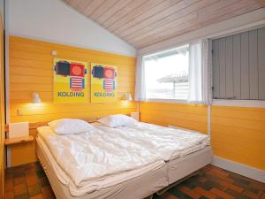 a bedroom with a large bed in a yellow room at 6 person holiday home in Hanstholm- Type1 in Hanstholm