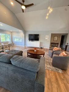 a living room with two couches and a table at Paradise Island escape Riverfront in Clay, NY in Clay