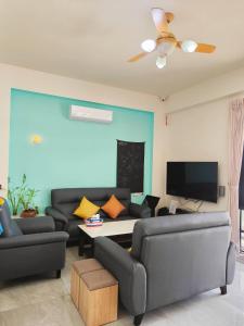 a living room with two couches and a tv at Lang duo duo Homestay in Huxi