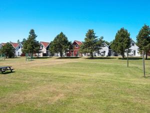 een park met een bankje en huizen op de achtergrond bij Holiday home with sauna, whirlpool- Type1 in Blåvand