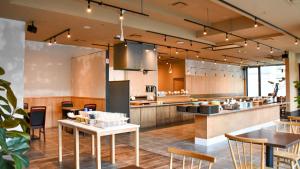 a large open kitchen with tables and chairs at Kotoni Green Hotel in Sapporo