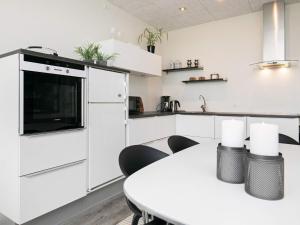 a white kitchen with a white table and chairs at Blokhus Feriecenter in Blokhus +76 photos