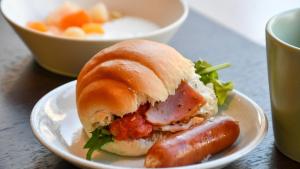a plate with a sausage and a bowl of soup at Kotoni Green Hotel in Sapporo +66 photos