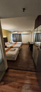 a hotel room with three beds and a desk at GR Ming garden SCSP in Kota Kinabalu