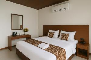 a bedroom with a large white bed and a mirror at Ivory Safari House in Udawalawe