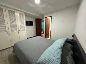a bedroom with a bed and a television in it at Apartamentos FM 204 in Líbano