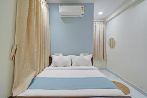 a bed in a room with a window at Hotel Broholi Height Inn Near Hafeezpet Railway Station in Hyderabad