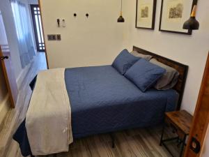 a bedroom with a bed with a blue comforter at Noa Loft in Miravalle