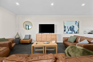 a living room with couches and a flat screen tv at Bayview Escape - Aldinga Beach - C21 SouthCoast Holidays in Aldinga Beach +18 photos