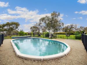 a swimming pool in a yard with a fence at Winterwood Lodge - 6mins Jindabyne -Pets Allow-Floor Heating Winter-Swimming Pool Summer in Moonbah