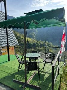 a picnic table and chairs under a green umbrella at warm house - sunrise merisi in Merisi +7 photos