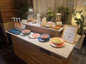 a buffet with bowls of food on a counter at Kotoni Green Hotel in Sapporo