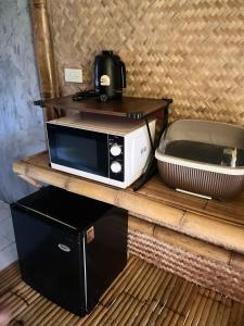 Un four micro-ondes est installé au-dessus d'une table en bois. dans l'établissement Lanta Thai Cottage, Bamboo House, à Ko Lanta Yai 19 autres photos