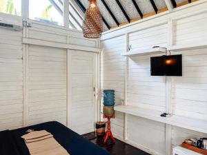 une chambre avec un lit et une télévision sur un mur dans l'établissement Bingin Sun & Moon Villas, à Bingin Beach