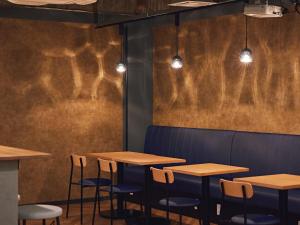 a row of tables and chairs in a restaurant at Shijo Guesthouse HIVE in Kyoto +34 photos