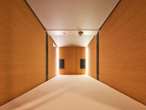 a corridor of a building with wooden walls at Shijo Guesthouse HIVE in Kyoto