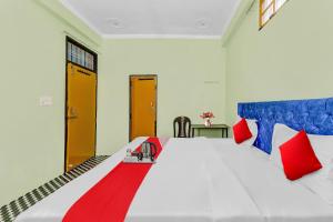 ein Schlafzimmer mit einem großen Bett mit roten und blauen Kissen in der Unterkunft Hotel O ADORA STAY in Bheta + 21 Fotos