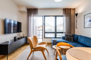 a living room with a blue couch and a table at Cranberry C11 Levi Center incl 2 ski passes by Aavalevi in Levi