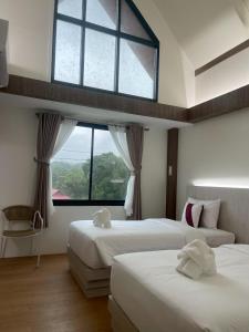 een slaapkamer met twee bedden en een groot raam bij Salty Sand Krabi Hotel in Ban Khlong Haeng