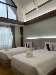 een hotelkamer met twee bedden en een raam bij Salty Sand Krabi Hotel in Ban Khlong Haeng +10 foto's