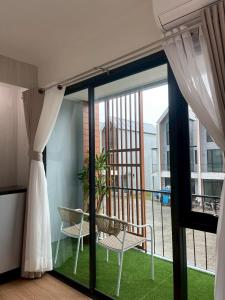 een kamer met een balkon met een stoel en een raam bij Salty Sand Krabi Hotel in Ban Khlong Haeng