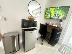 a room with a desk and a television and a mirror at POOLSIDE MANOR - Men Only Clothing-Optional in Fort Lauderdale