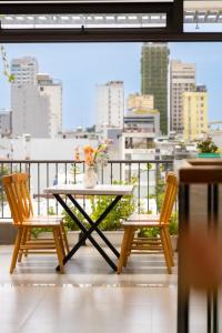 ein Tisch und zwei Stühle auf einem Balkon mit Aussicht in der Unterkunft Sóng homestay 4 - The spacious house - In the Prime location in Đà Nẵng