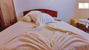 a bed with a blanket on top of it at Résidence Suzanne in Brazzaville