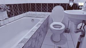 a bathroom with a tub and a toilet and a sink at Résidence Suzanne in Brazzaville