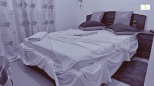 a large bed with white sheets and pillows at Résidence Suzanne in Brazzaville +62 photos