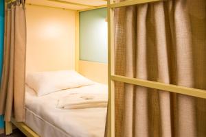 ノヴォシビルスクにあるHostel Evraziaのベッドルーム(二段ベッド1組、カーテン付)