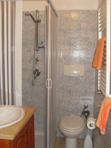 y baño con ducha, aseo y lavamanos. en B&B Frammenti D'Itria, en Ceglie Messapica