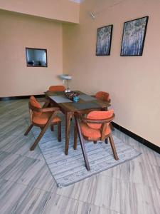 a dining room with a wooden table and chairs at Express living and wellness in Jinja