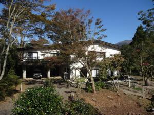霧島市にある～みらい荘～　天然温泉付き一日一組様限定の６４坪広々民泊別荘の目の前に木々が植えられた白い家