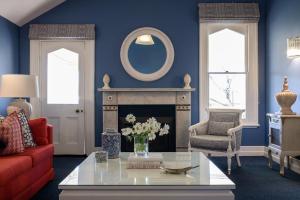 a living room with a red couch and a fireplace at Yallungah Boutique Hotel in Orange