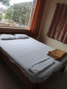 a bed in a room with a window at Sohan Boarding and Lodging in Perdūru