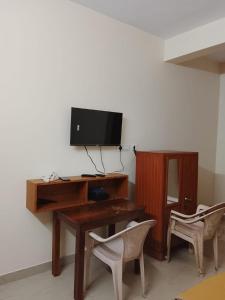 a desk with a television on a wall with two chairs at Sohan Boarding and Lodging in Perdūru +21 photos