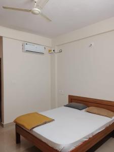 a white bedroom with a bed with a ceiling at Sohan Boarding and Lodging in Perdūru