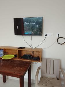 a desk with a television and a table with a chair at Sohan Boarding and Lodging in Perdūru