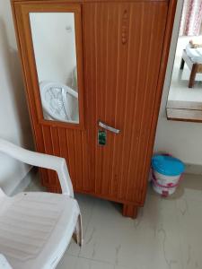 a wooden cabinet with a white chair in a room at Sohan Boarding and Lodging in Perdūru