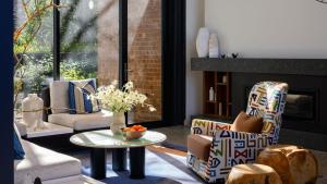 un soggiorno con sedie, tavolo e camino di Yallungah Boutique Hotel a Orange