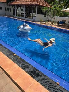 a person floating in a swimming pool in a swimming pool at Blue Kite Retreat in Kalpitiya