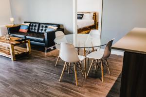 ein Wohnzimmer mit einem Glastisch und Stühlen in der Unterkunft The Spot - Fully Furnished 2 Bedrooms Apartment in Winnipeg in Tuxedo + 19 Fotos