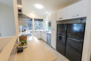 een keuken met een zwarte koelkast en witte kasten bij Sandcastles 2 in Point Lookout