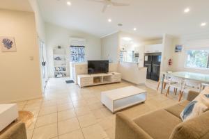 een woonkamer met een bank, een tv en een tafel bij Sandcastles 2 in Point Lookout