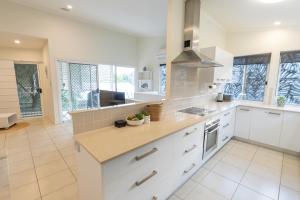 een keuken met witte kasten en een aanrechtblad bij Sandcastles 2 in Point Lookout +8 foto's